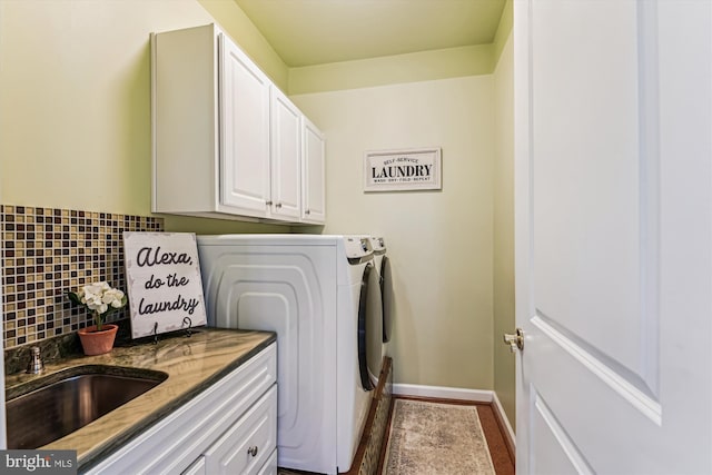 washroom featuring washer and dryer, sink, and cabinets