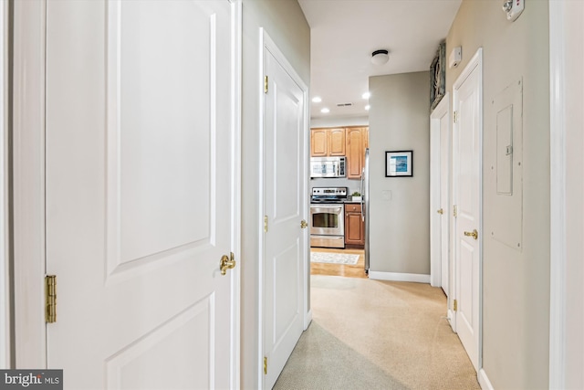 hallway featuring light colored carpet