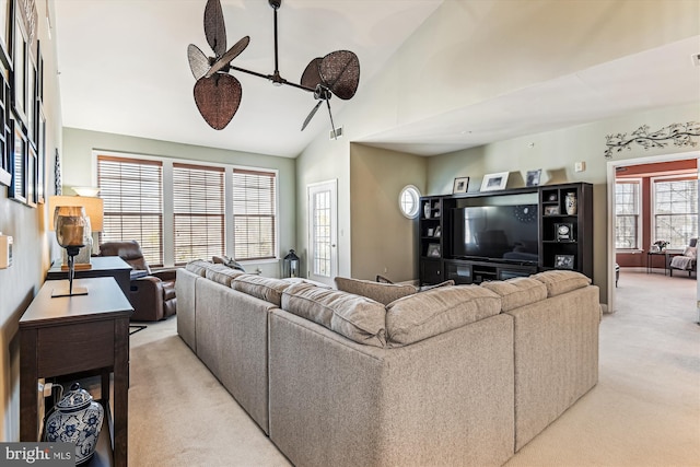 living room featuring high vaulted ceiling, light colored carpet, and ceiling fan