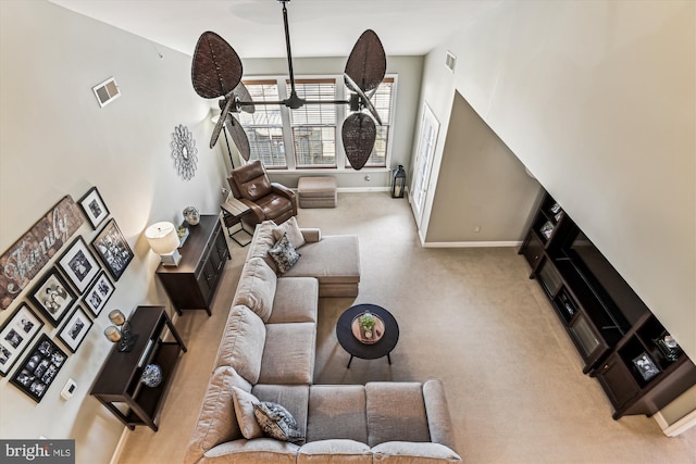 carpeted living room with a high ceiling