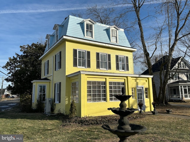 view of front facade with ac unit and a front lawn