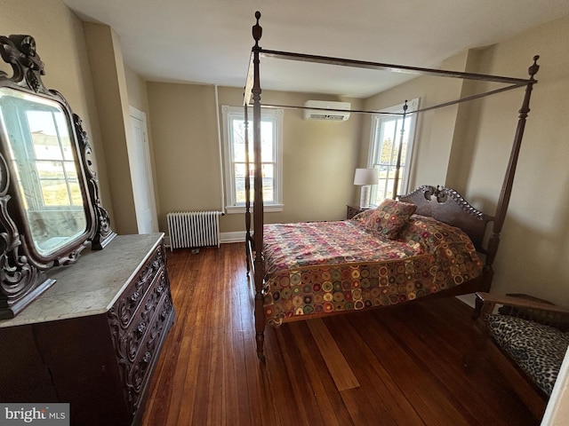 bedroom with dark hardwood / wood-style flooring, radiator, and a wall unit AC