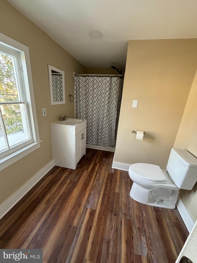 bathroom featuring walk in shower, toilet, vaulted ceiling, vanity, and hardwood / wood-style floors