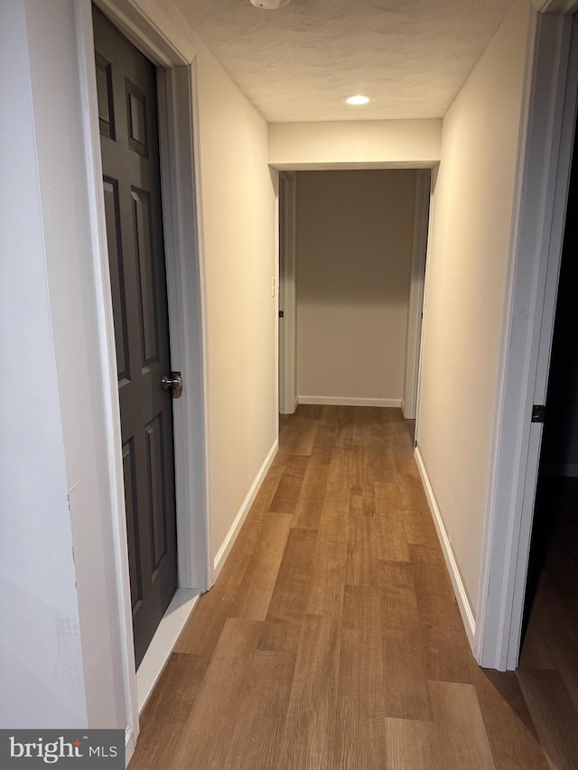 corridor with light hardwood / wood-style floors