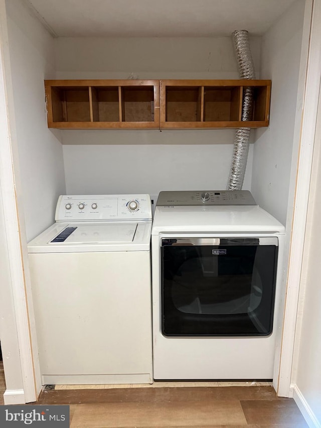 laundry area with light hardwood / wood-style floors and washing machine and clothes dryer