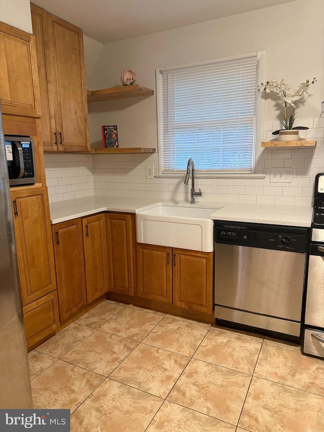 kitchen featuring tasteful backsplash, appliances with stainless steel finishes, sink, and light tile patterned floors