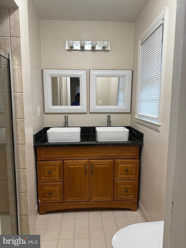 bathroom featuring vanity, toilet, tile patterned flooring, and a shower with door