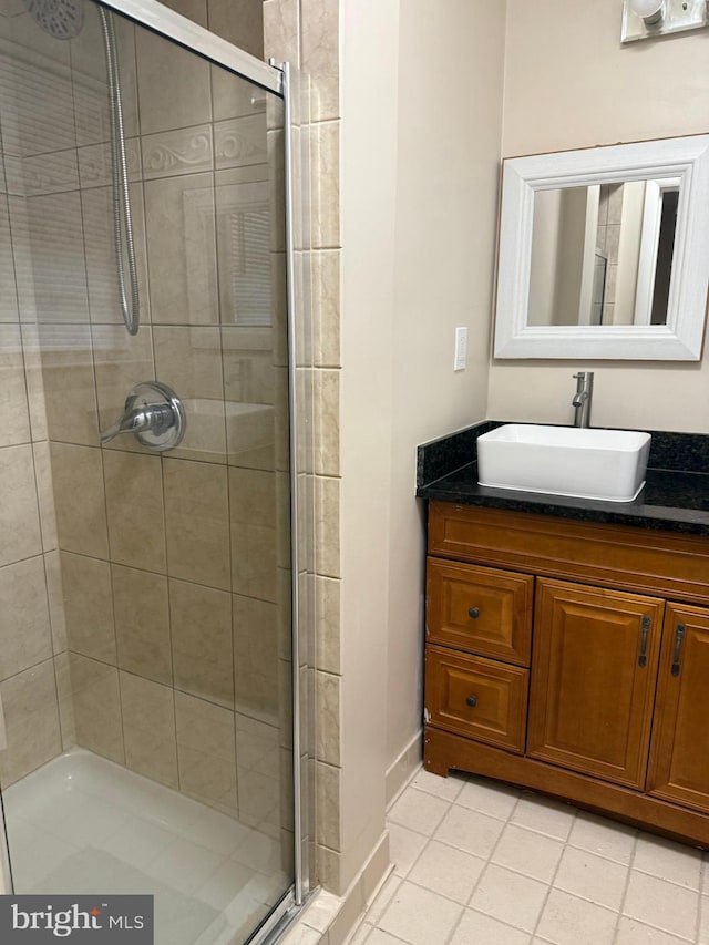 bathroom featuring tile patterned flooring, vanity, and an enclosed shower