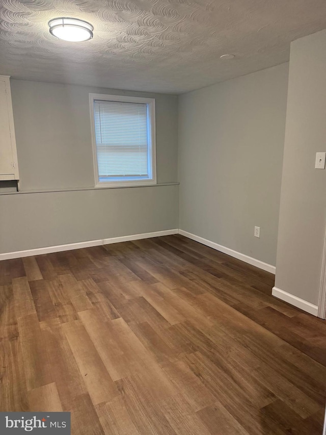 unfurnished room featuring hardwood / wood-style floors and a textured ceiling