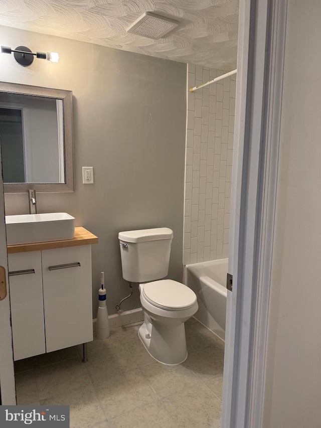 full bathroom featuring vanity, toilet, tiled shower / bath combo, and tile patterned flooring