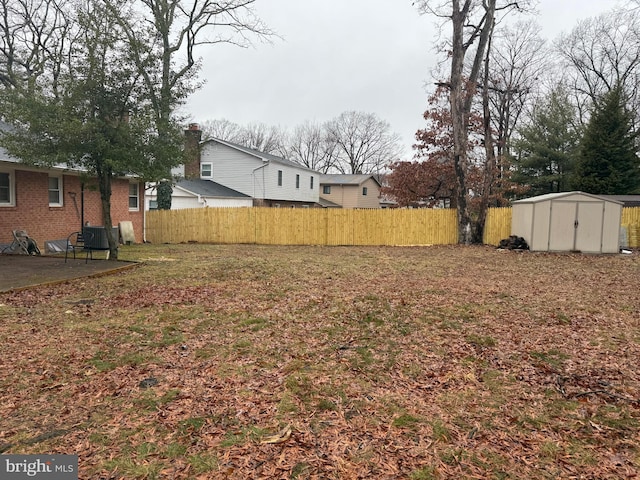 view of yard featuring a storage unit and central AC unit