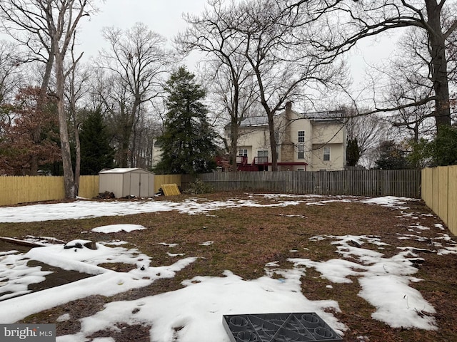 yard covered in snow featuring a storage shed