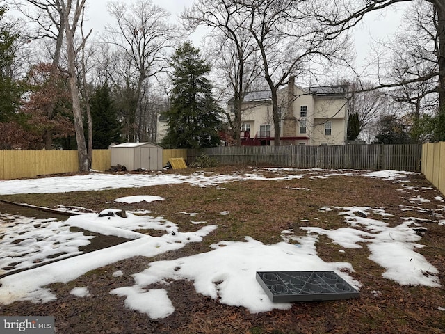 snowy yard featuring a storage shed