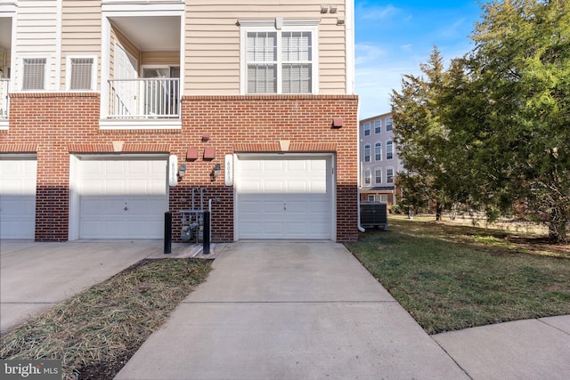 view of property featuring a garage, a balcony, a front yard, and central air condition unit