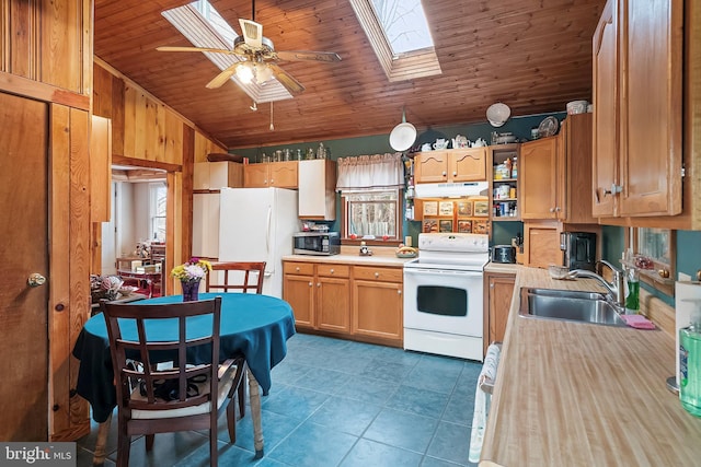 kitchen with lofted ceiling with skylight, sink, dark tile patterned flooring, wood ceiling, and white appliances