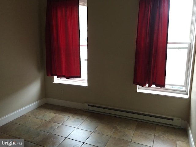 tiled empty room with a baseboard radiator