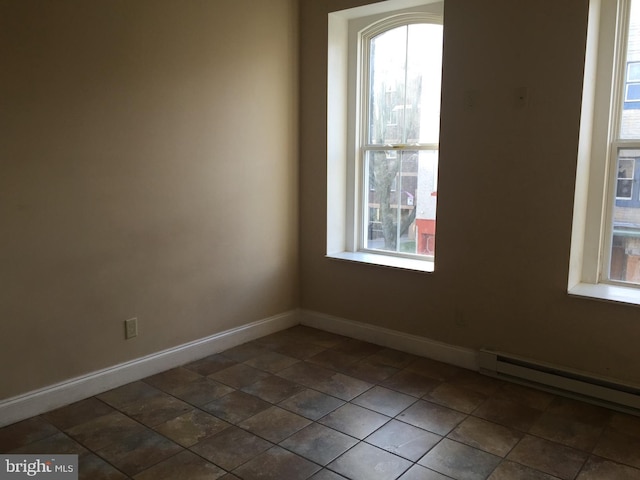 empty room with a healthy amount of sunlight and baseboard heating