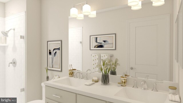 bathroom with double vanity, tiled shower, a chandelier, and a sink