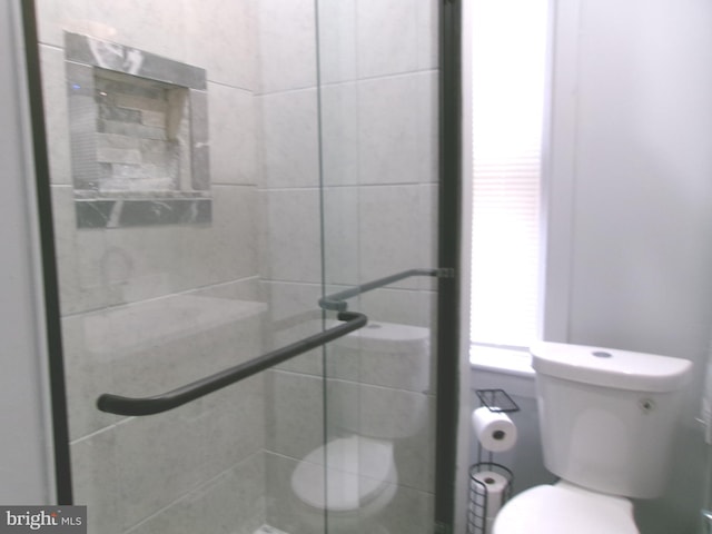 bathroom featuring an enclosed shower and toilet