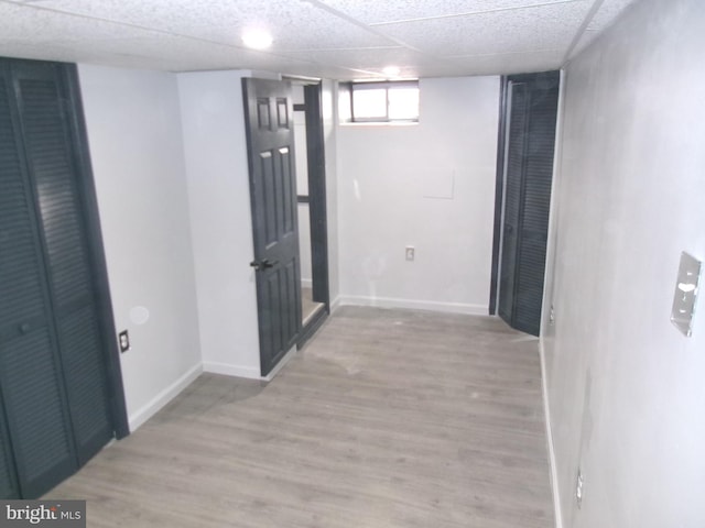 corridor featuring a drop ceiling and light hardwood / wood-style flooring