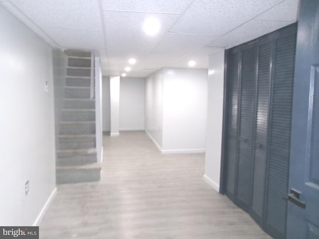 corridor with hardwood / wood-style floors and a drop ceiling