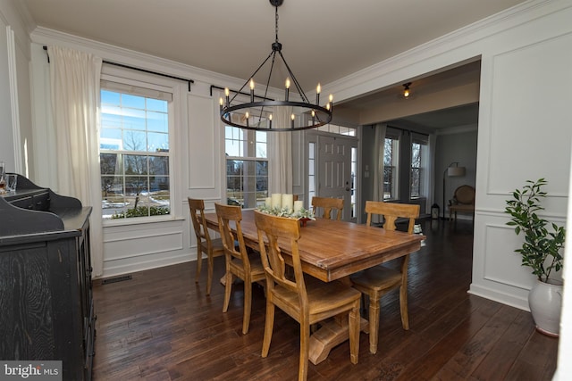 dining room featuring crown molding, dark wood-type flooring, and an inviting chandelier