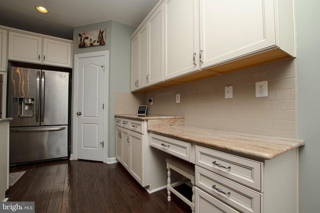 kitchen featuring white cabinetry, dark hardwood / wood-style flooring, stainless steel fridge, and light stone countertops