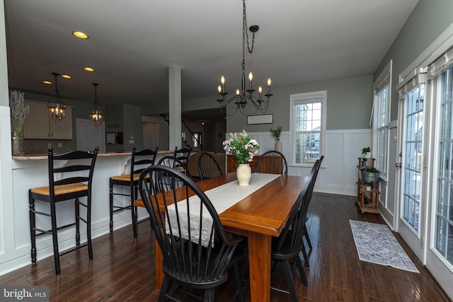 dining area featuring dark wood-type flooring and a notable chandelier