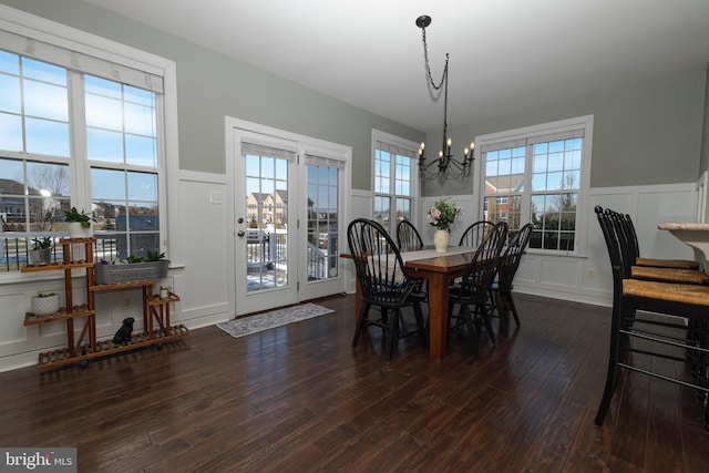 dining room with an inviting chandelier and dark wood-type flooring