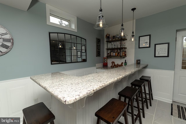 bar featuring light tile patterned floors and decorative light fixtures