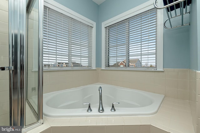 bathroom featuring independent shower and bath