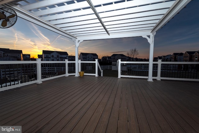 deck at dusk featuring a pergola