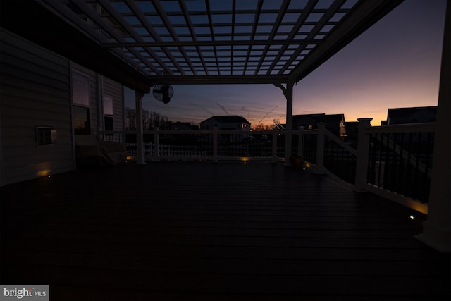 deck at dusk featuring a pergola