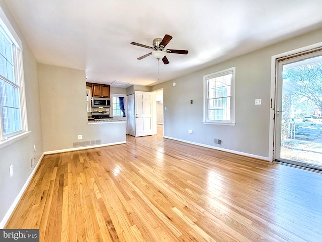 unfurnished living room featuring ceiling fan and light wood-type flooring