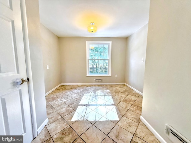 tiled empty room featuring a baseboard radiator