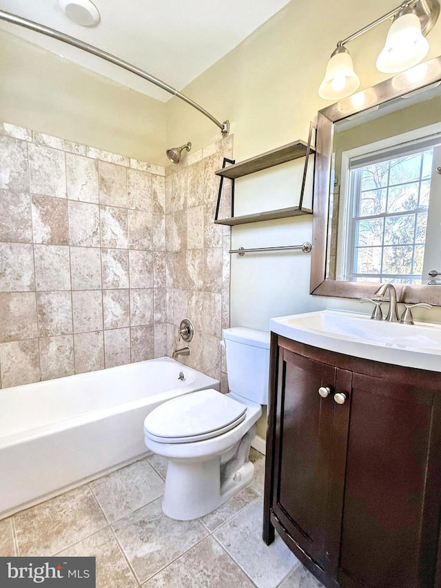 full bathroom with vanity, tiled shower / bath, tile patterned floors, and toilet