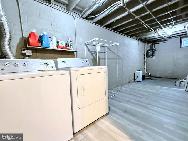 washroom with light hardwood / wood-style flooring and washing machine and dryer