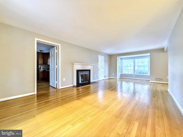 unfurnished living room with hardwood / wood-style flooring and a premium fireplace