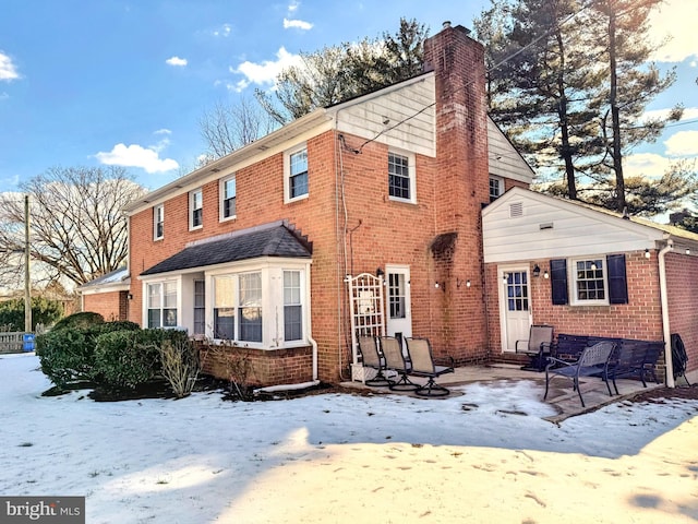 view of snow covered back of property