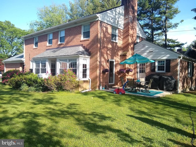 back of house with a patio and a lawn