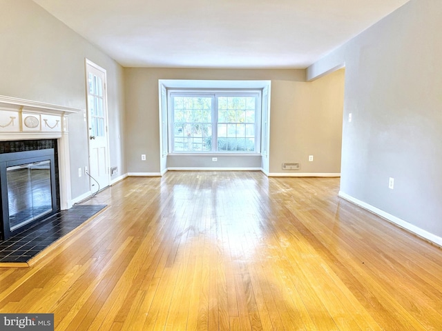 unfurnished living room featuring a fireplace and wood-type flooring