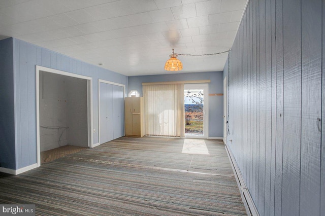 interior space with carpet flooring and wood walls