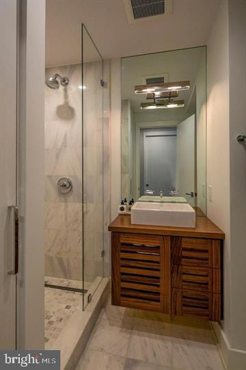 bathroom with a shower with door and vanity