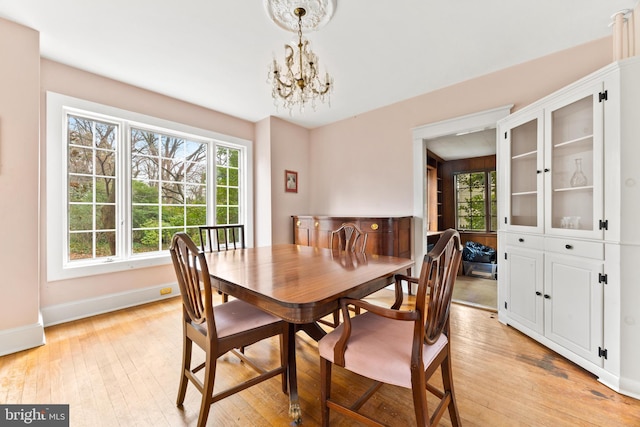 dining space with an inviting chandelier, light hardwood / wood-style flooring, and a wealth of natural light