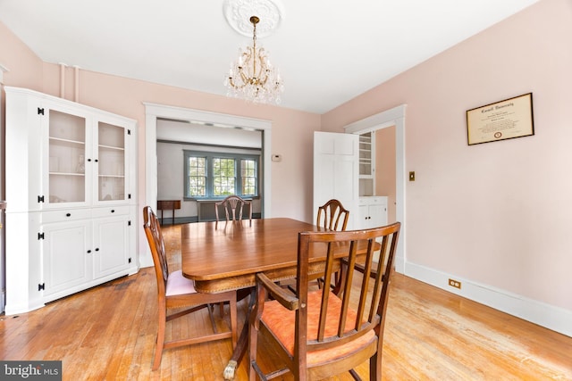 dining area with a chandelier and light wood-type flooring