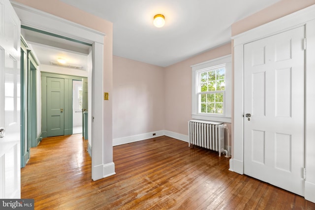 interior space featuring radiator heating unit and hardwood / wood-style floors