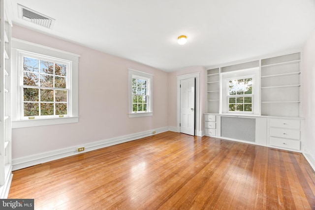 unfurnished bedroom with radiator heating unit and light wood-type flooring