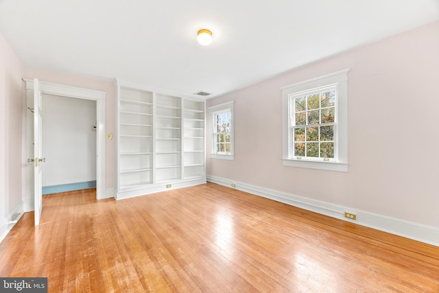 empty room featuring built in features and light wood-type flooring