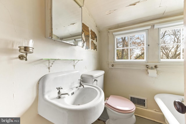 bathroom featuring plenty of natural light and toilet