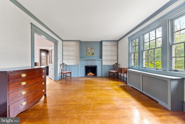 living room featuring built in shelves and light hardwood / wood-style floors